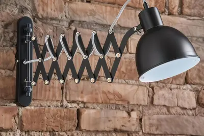 a black light hanging on a brick wall with a row of knives at Cracow Fancy Brick #1 - Old Town in Kraków