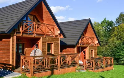a log cabin with a black roof and a deck at 3 Bedroom Awesome Home In Barwald Dolny in Barwałd Dolny