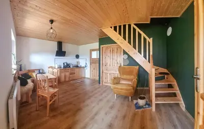 a living room with a wooden staircase in a house at 3 Bedroom Awesome Home In Barwald Dolny in Barwałd Dolny