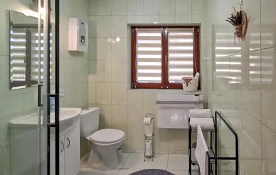 a white bathroom with a toilet and a window at 3 Bedroom Awesome Home In Barwald Dolny in Barwałd Dolny