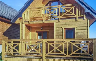 a wooden house with a wooden fence in front of it at 3 Bedroom Awesome Home In Barwald Dolny in Barwałd Dolny