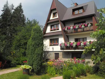 a building with flower boxes on the balcony at Pokoje Gościnne - Za Borem in Zubrzyca Górna