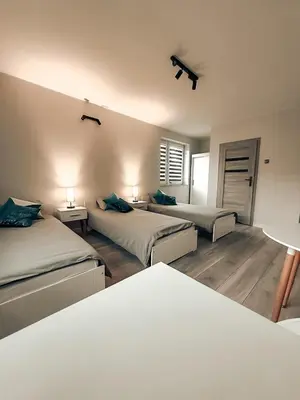 a bedroom with two beds and two tables and two lamps at Zosieńka in Podolsze