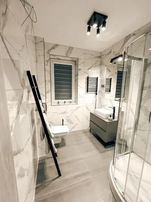 a white bathroom with two sinks and a shower at Zosieńka in Podolsze