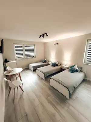 a bedroom with two beds and a table and a desk at Zosieńka in Podolsze