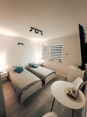 a bedroom with two beds and a table and a tv at Zosieńka in Podolsze