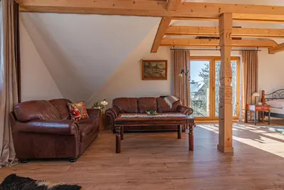 a living room with a leather couch and a coffee table at Apartamenty Baj na Polnej - bezpłatny parking, widok na góry i zewnętrzna balia! in PyzÃ³wka