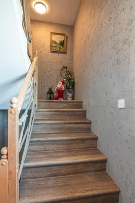 a staircase in a house with a person sitting in a chair at Apartamenty Baj na Polnej - bezpłatny parking, widok na góry i zewnętrzna balia! in PyzÃ³wka