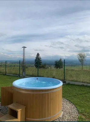 a hot tub with a bench in a yard at Domki z Widokiem Klikuszowa jacuzzi in Klikuszowa