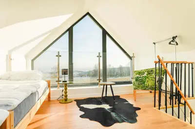 a bedroom with a bed and a large window at Domki z Widokiem Klikuszowa jacuzzi in Klikuszowa