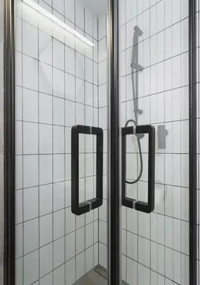 a glass shower door with two mirrors in a bathroom at Golden Honey Apartments in Kraków