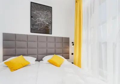 a bedroom with a bed with two yellow pillows at Golden Honey Apartments in Kraków