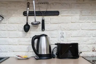 a tea kettle and utensils hanging on a wall at Park Kleparski Comfort Studio by BookingHost in Kraków