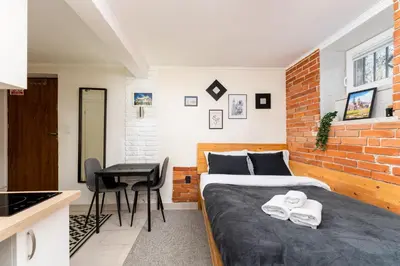 a bedroom with a bed and a desk in a room at Park Kleparski Comfort Studio by BookingHost in Kraków