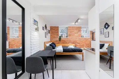 a bedroom with two beds and a table and chairs at Park Kleparski Comfort Studio by BookingHost in Kraków