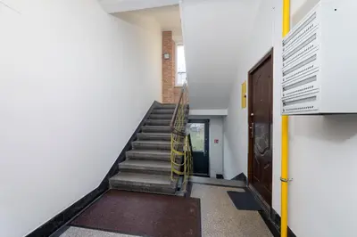 a staircase in a building with a yellow hand rail at Park Kleparski Comfort Studio by BookingHost in Kraków