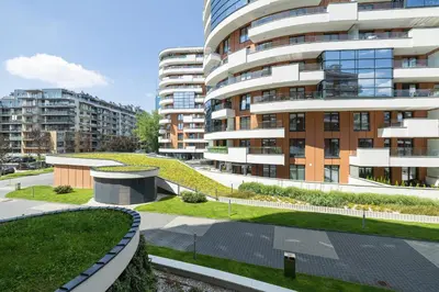 an apartment building with a garden in front of it at Elegancki Apartament z Balkonem dla 4 osób by Noclegi Renters in Kraków