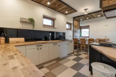 a large kitchen with white cabinets and a checkered floor at Górski Dom dla 30 osób z sauna oraz salą do integracji in Kocierz Rychwałdzki