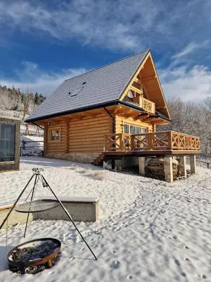 a log cabin in the snow with a snowboard in front of it at Dom z Bali Zawoja z widokiem na Babią Górę in Stryszawa