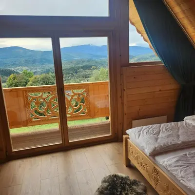 a bedroom with a bed and a large window at Dom z Bali Zawoja z widokiem na Babią Górę in Stryszawa