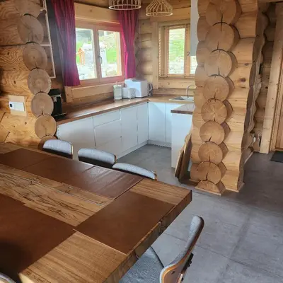 a kitchen with wooden walls and a table and chairs at Dom z Bali Zawoja z widokiem na Babią Górę in Stryszawa