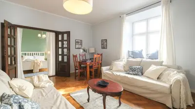 a bedroom with a bed with green walls and a window at Vintage apartments Floriańska street - By Hosty in Kraków