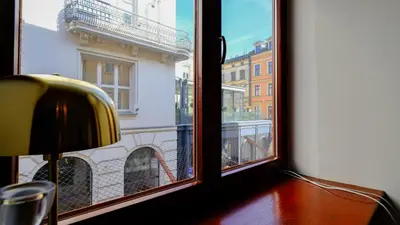 a living room with a table and chairs and a television at Vintage apartments Floriańska street - By Hosty in Kraków