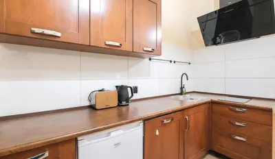 a kitchen with wooden cabinets and a sink at Vintage apartments Floriańska street - By Hosty in Kraków