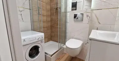 a bathroom with a washing machine and a toilet at A cozy apartment in the heart of the city in Kraków