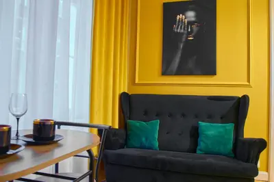 a dining room with a black chair and a table at A cozy apartment in the heart of the city in Kraków