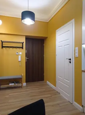 an empty room with a white door and yellow walls at A cozy apartment in the heart of the city in Kraków