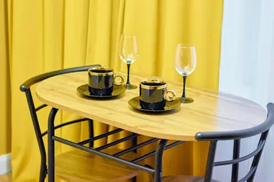 a wooden table with two cups and two wine glasses at A cozy apartment in the heart of the city in Kraków