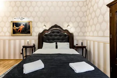 a bedroom with a large bed with two pillows on it at Exclusive Royal Apartments in Kraków