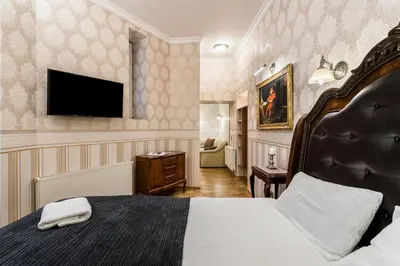 a hotel room with a bed and a flat screen tv at Exclusive Royal Apartments in Kraków