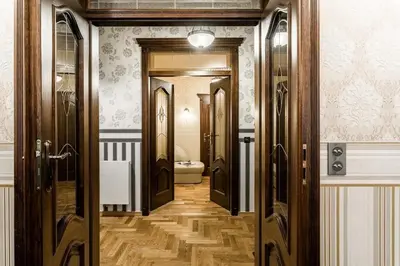 a hallway with wooden doors and a toilet at Exclusive Royal Apartments in Kraków