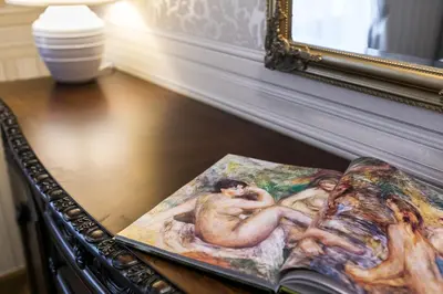 a book on a table with a painting on it at Exclusive Royal Apartments in Kraków
