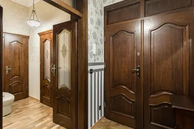a bathroom with wooden doors and a toilet at Exclusive Royal Apartments in Kraków