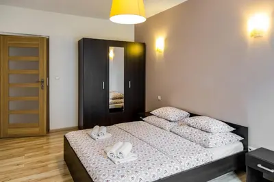 a bedroom with a bed with two white towels on it at Apartments of Pawia in Kraków