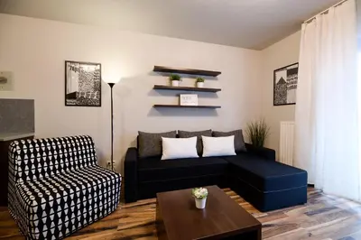 a living room with a couch and a chair at Apartments of Pawia in Kraków