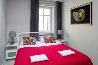 a bedroom with a large red bed with two pillows at Central & comfortable apartment in Kraków