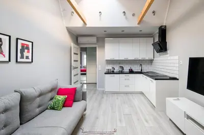 a living room with a couch and a kitchen at Central & comfortable apartment in Kraków