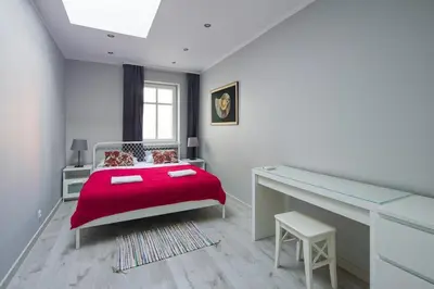 a bedroom with a red bed and a desk at Central & comfortable apartment in Kraków