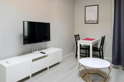 a living room with a tv and a table with chairs at Central & comfortable apartment in Kraków