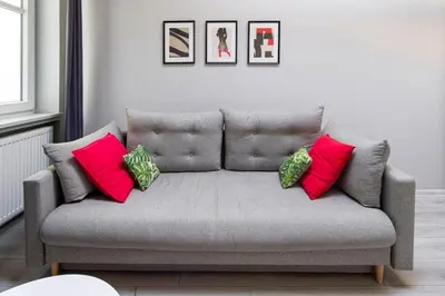 a couch with four pillows on it in a living room at Central & comfortable apartment in Kraków