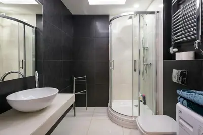 a bathroom with a sink and a glass shower at Elegant apartment 5 minutes from Wawel Castle in Kraków