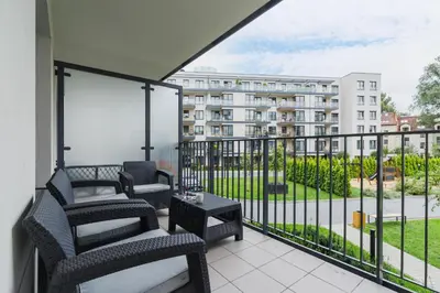 a balcony with chairs and a view of a building at Apartament 3d Wilga by Noclegi Renters in Kraków