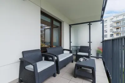 a balcony with chairs and a table on a building at Apartament 3d Wilga by Noclegi Renters in Kraków