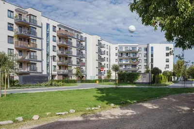 a large white apartment building with a ball in the sky at Apartament 3d Wilga by Noclegi Renters in Kraków