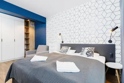 a bedroom with a bed and a blue and white wall at Apartament 3d Wilga by Noclegi Renters in Kraków