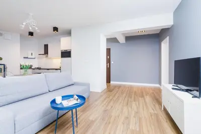 a living room with a couch and a table at Apartament 3d Wilga by Noclegi Renters in Kraków